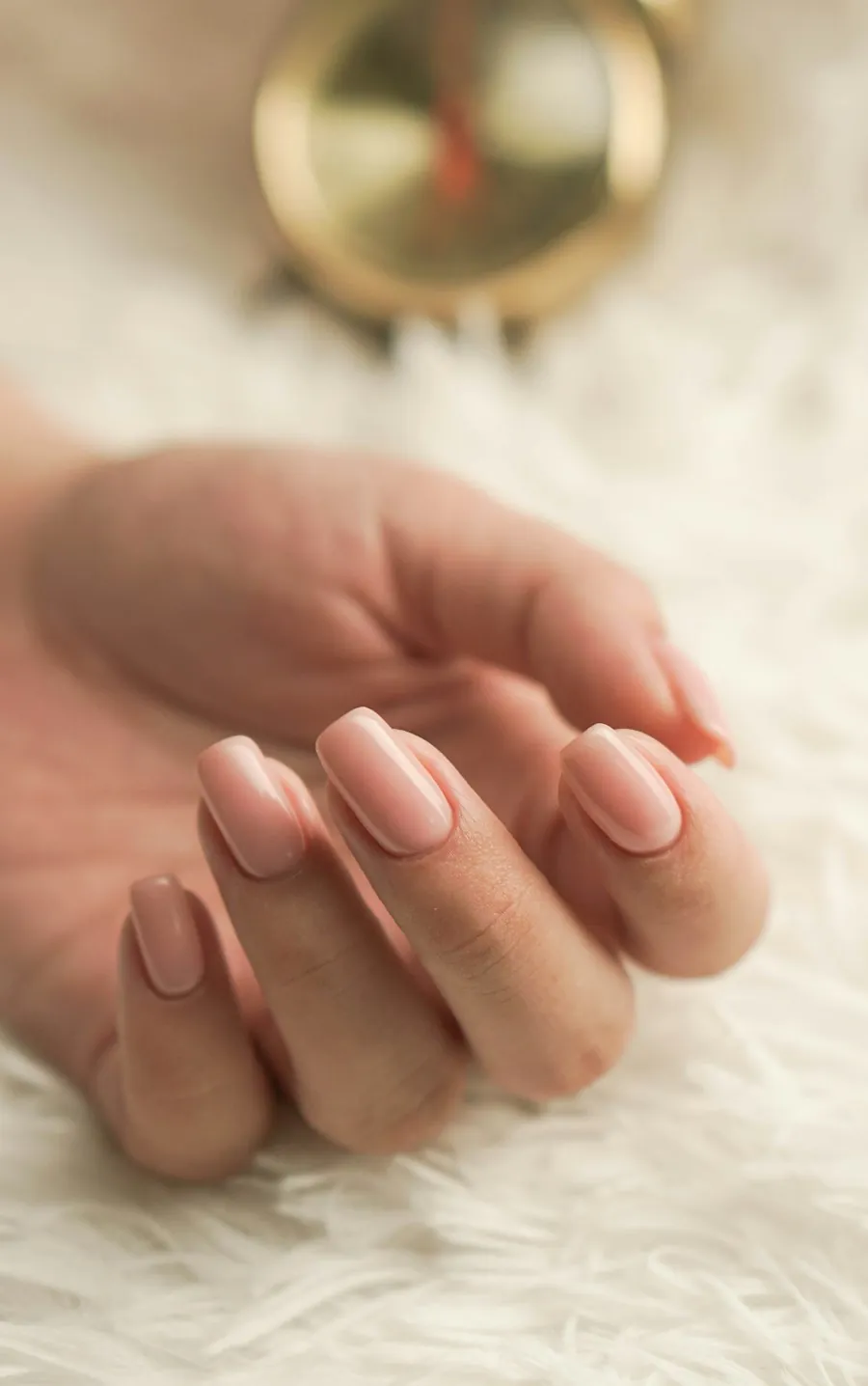 Une main aux ongles nude, vernis semi-permanent
